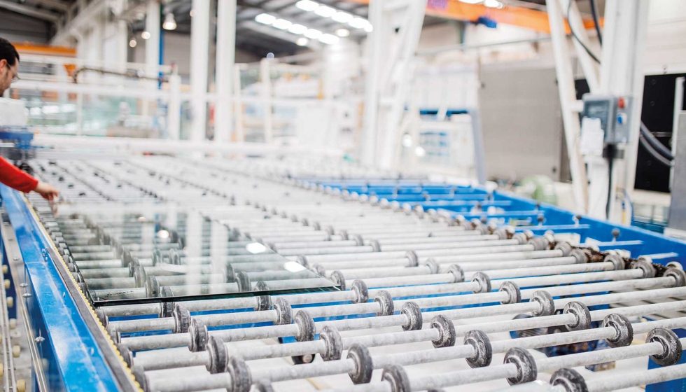 Bright modern factory in China with glass panels moving along a production conveyor